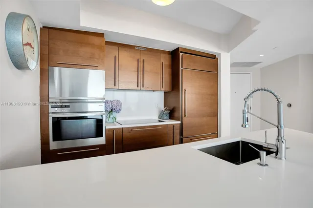 a kitchen with a refrigerator sink and cabinets