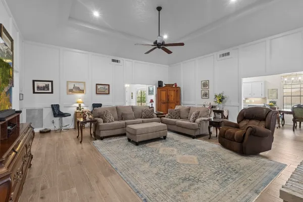 a living room with furniture a fireplace and a chandelier