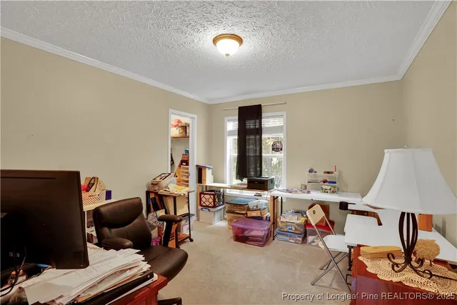 a view of a workspace with furniture and a window