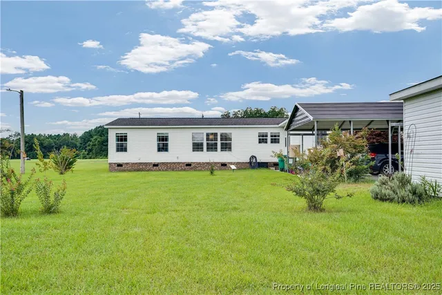 a view of an house with backyard space and balcony