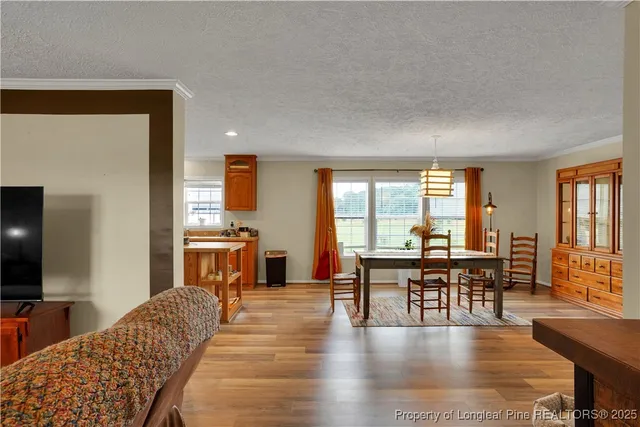 a living room with furniture a dining table and chairs with wooden floor