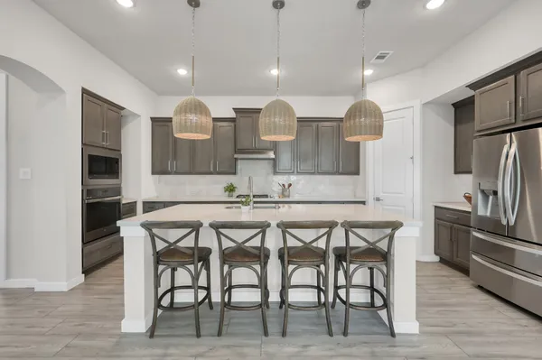 a kitchen with stainless steel appliances kitchen island granite top and refrigerator