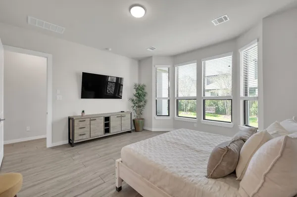 a bedroom with a bed and a flat screen tv on dresser