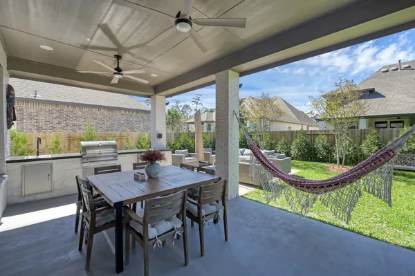 a patio with a table and chairs and potted plants