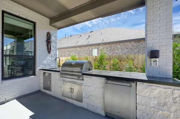 a view of a patio with couches table and chairs with wooden fence