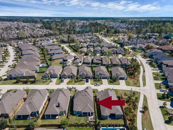 an aerial view of a house with a garden and lake view