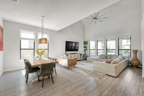 a living room with furniture flat screen tv and a large window