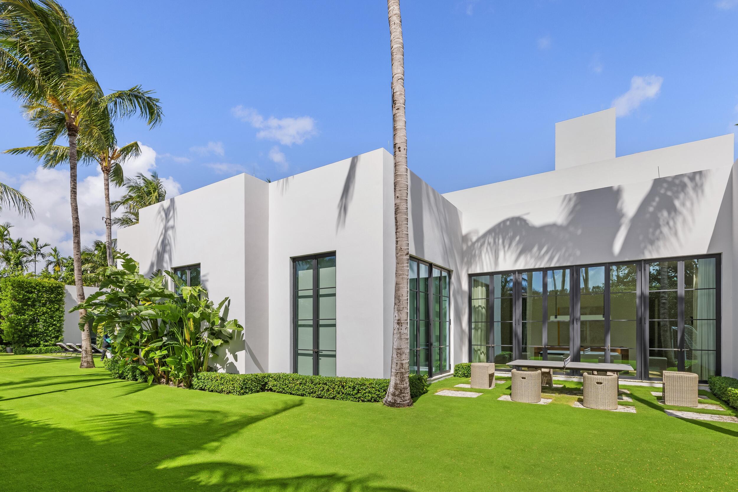 241 Jungle Road Palm Beach, FL 33480 - Photo 22 of 96 a patio with a table and chairs and potted plants