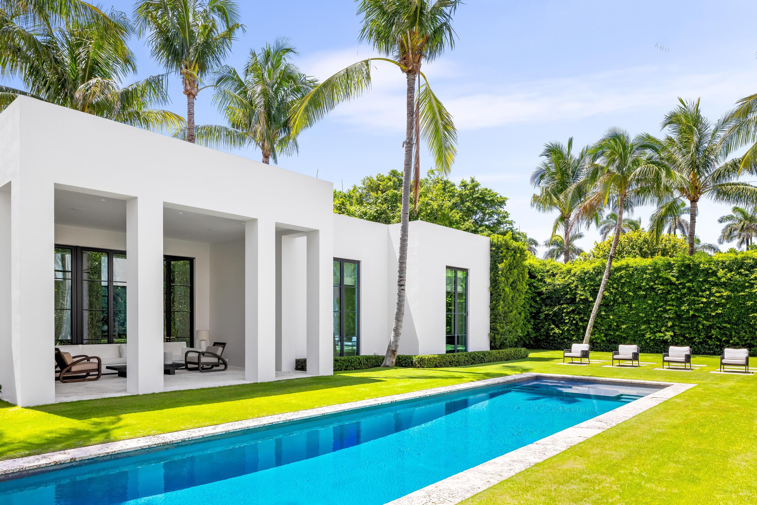 241 Jungle Road Palm Beach, FL 33480 - Photo 73 of 96 a view of a swimming pool with a yard and palm trees