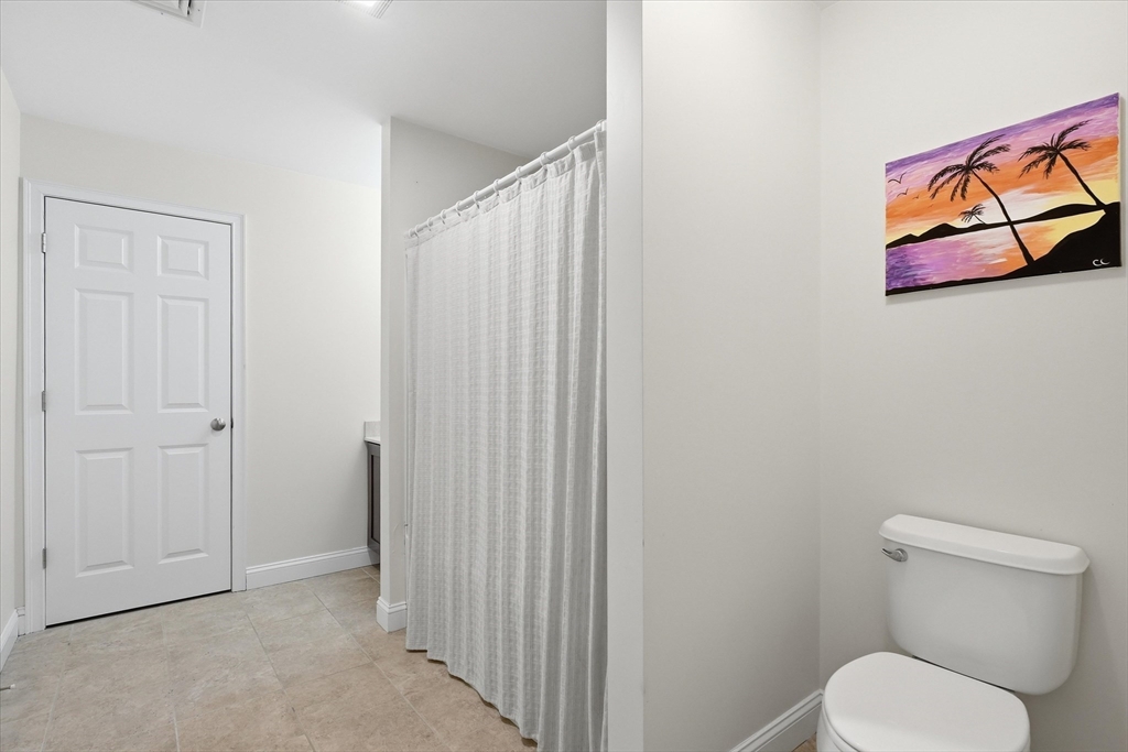2 B Gates Lane, Unit B Wakefield, MA 01880 - Photo 24 of 42 a white toilet sitting next to a shower curtain