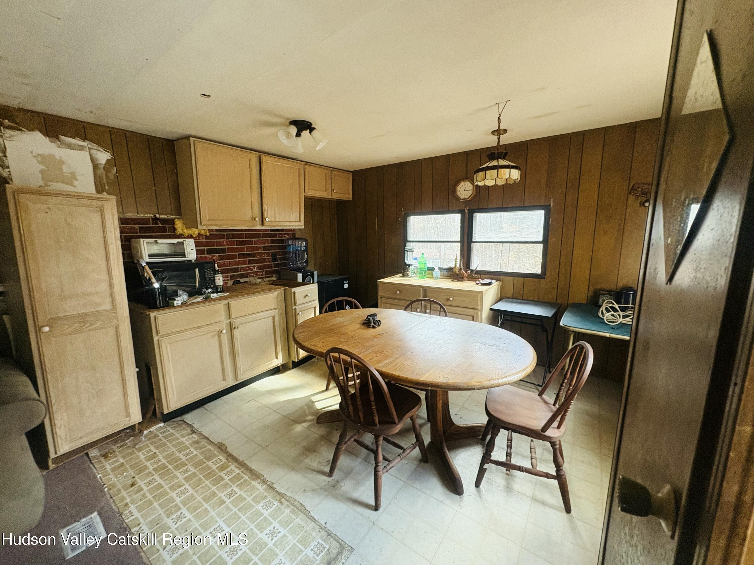238 Buel Road Gilboa, NY 12076 - Photo 5 of 13 a kitchen with stainless steel appliances a dining table chairs refrigerator and sink