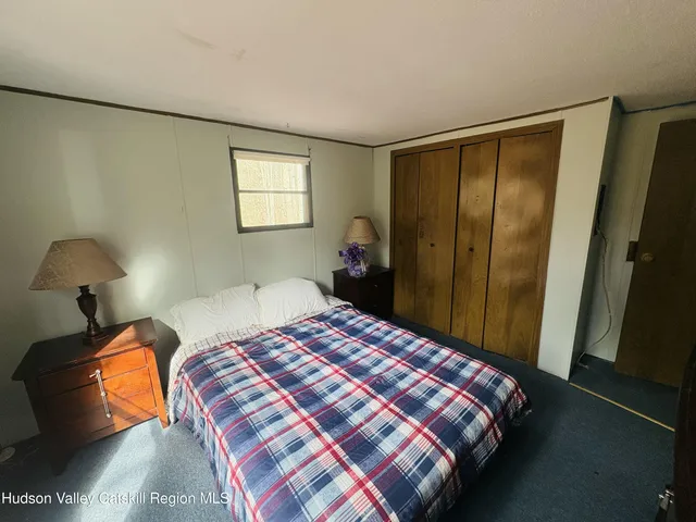 a bedroom with a bed and window with lamp