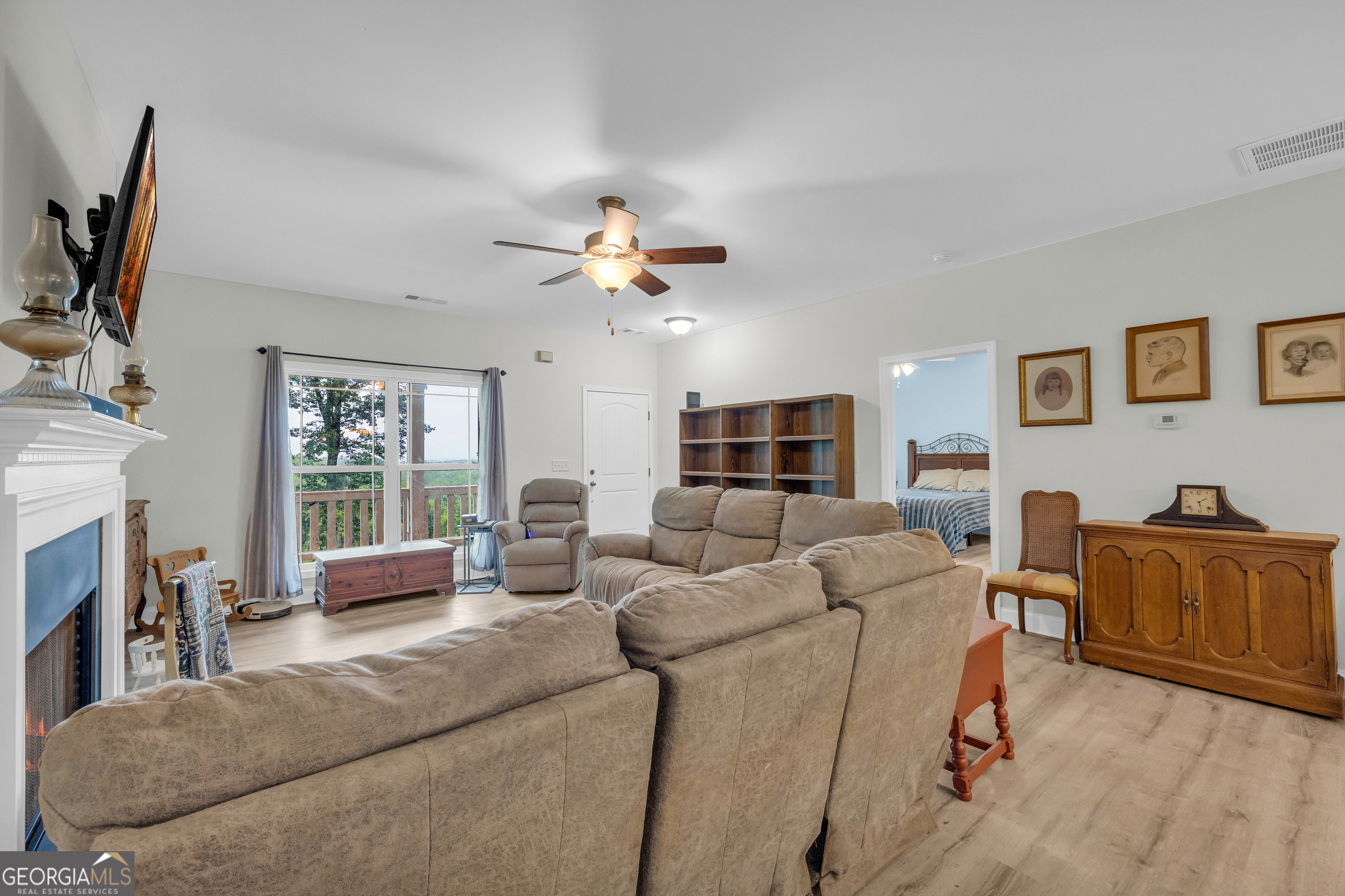 945 Hank Fry Road Clarkesville, GA 30523 - Photo 16 of 45 a living room with furniture a flat screen tv and a fireplace