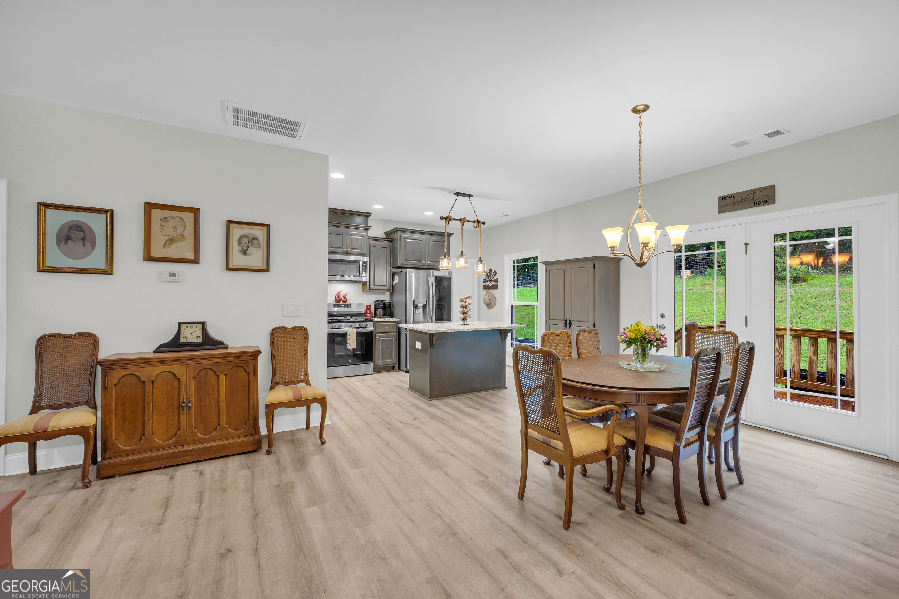 945 Hank Fry Road Clarkesville, GA 30523 - Photo 17 of 45 a dining room with furniture a chandelier and wooden floor
