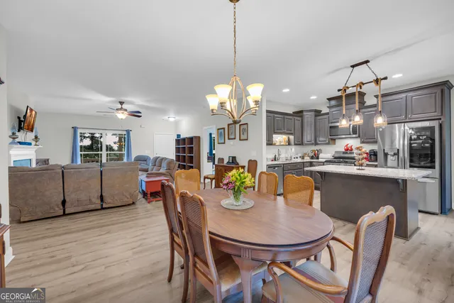 a dining room filled chandelier and wooden floor