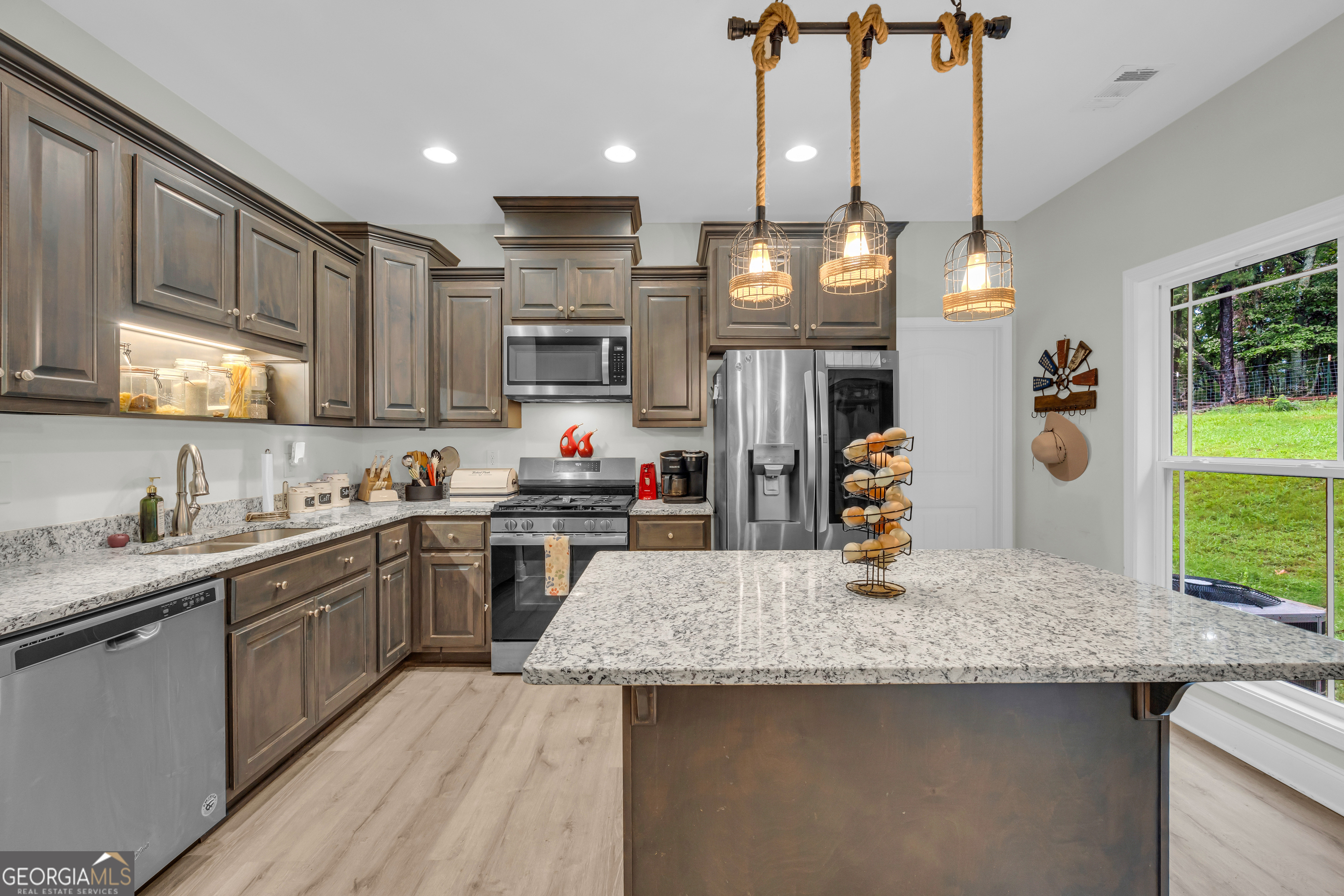 945 Hank Fry Road Clarkesville, GA 30523 - Photo 23 of 45 a kitchen with stainless steel appliances granite countertop a sink a stove and a wooden floors