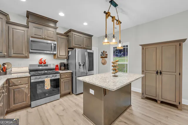 a kitchen with stainless steel appliances a stove refrigerator sink and microwave