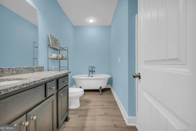 a bathroom with a granite countertop sink a toilet and bathtub