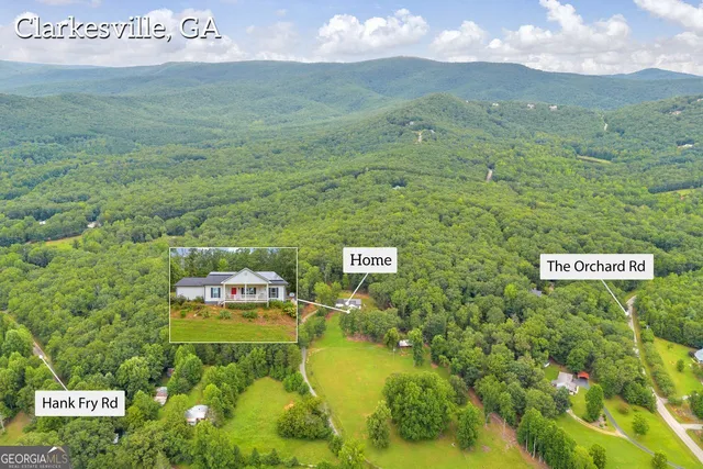 a view of a sign board with yard and mountain view