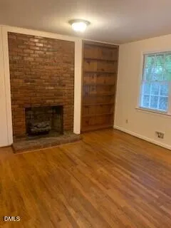 a view of an empty room with a fireplace and a window