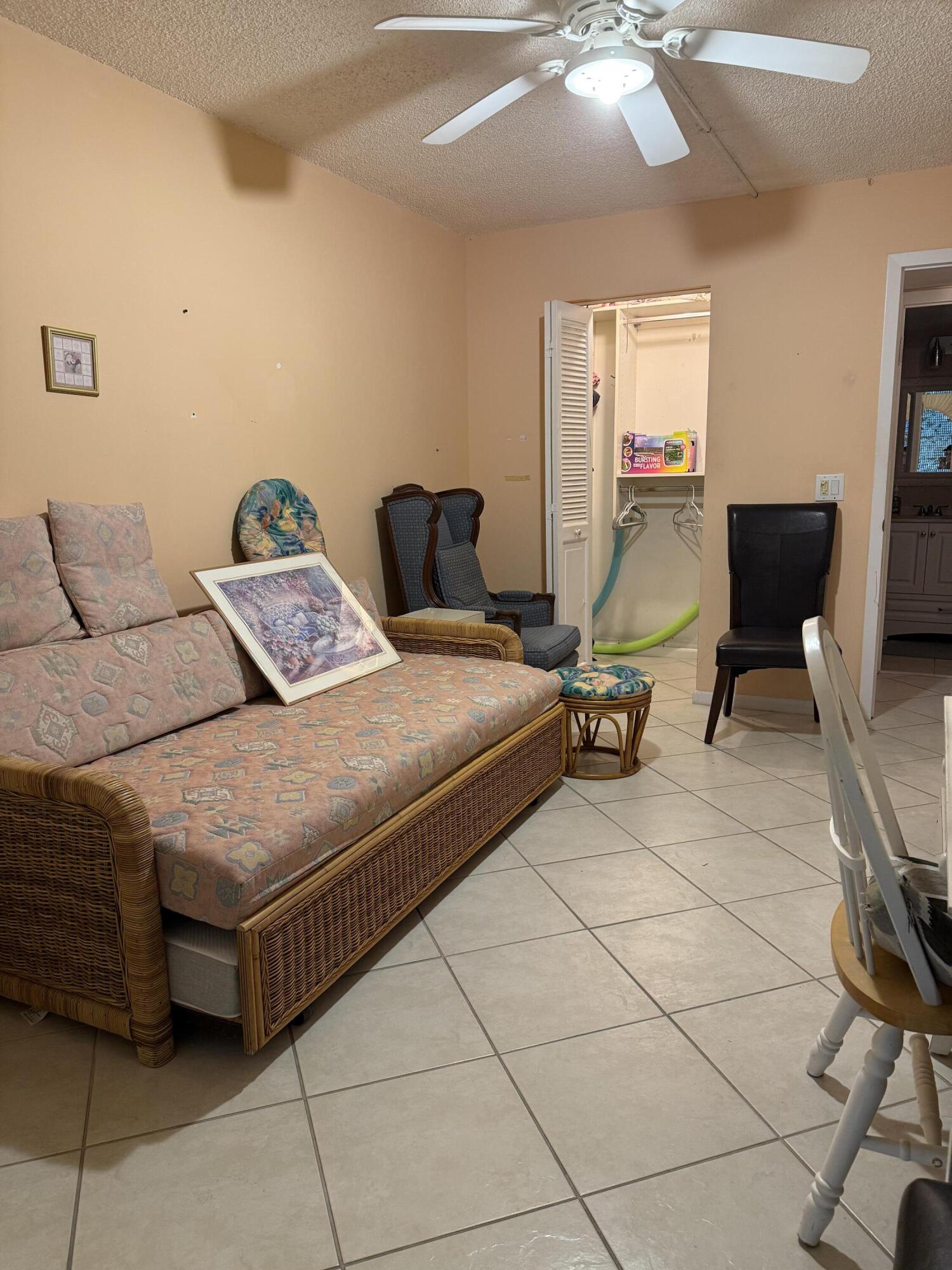 1046 Wolverton C Boca Raton, FL 33434 - Photo 12 of 17 a bedroom with a bed a table and chair