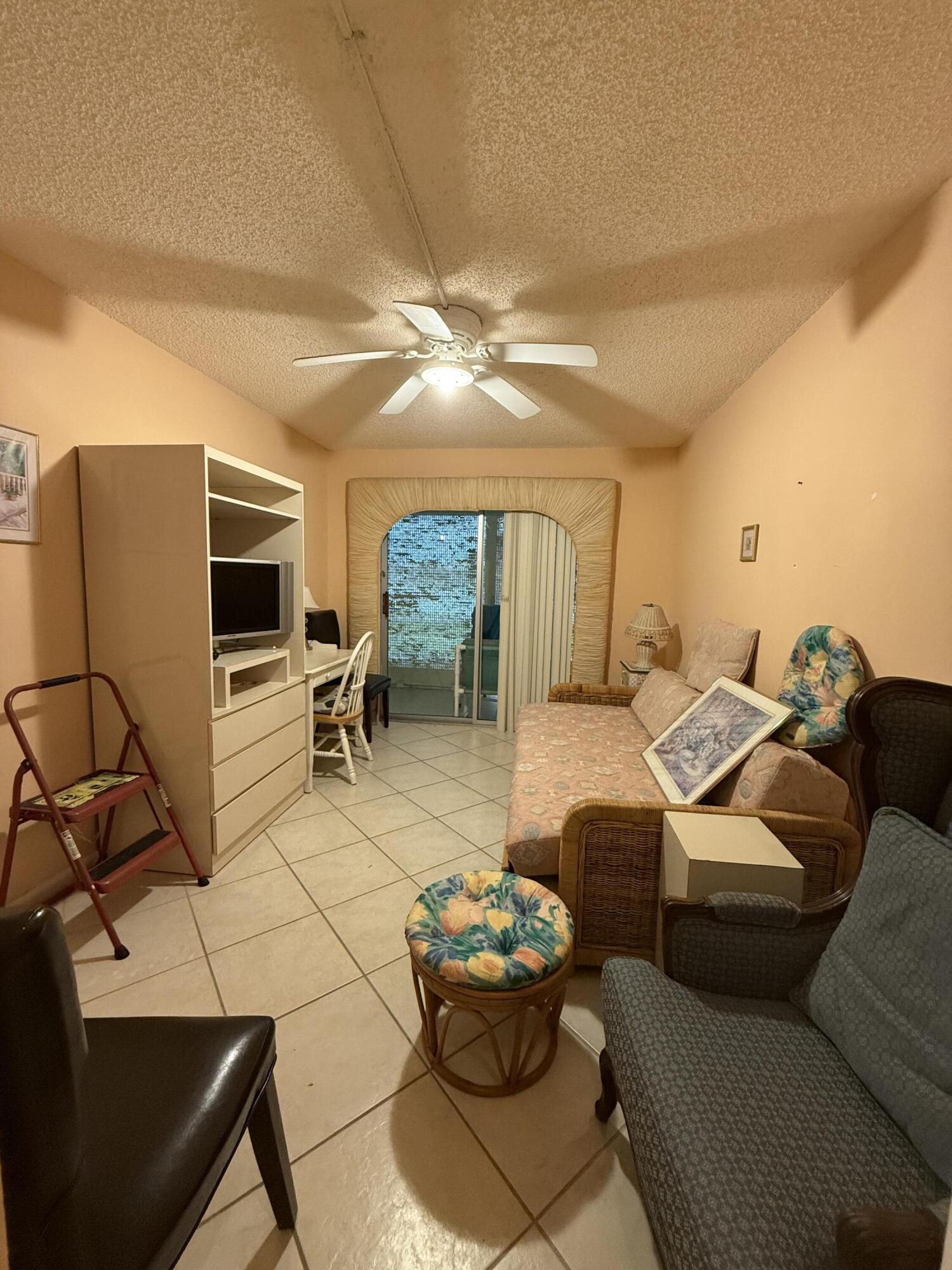 1046 Wolverton C Boca Raton, FL 33434 - Photo 13 of 17 a living room with furniture and a flat screen tv