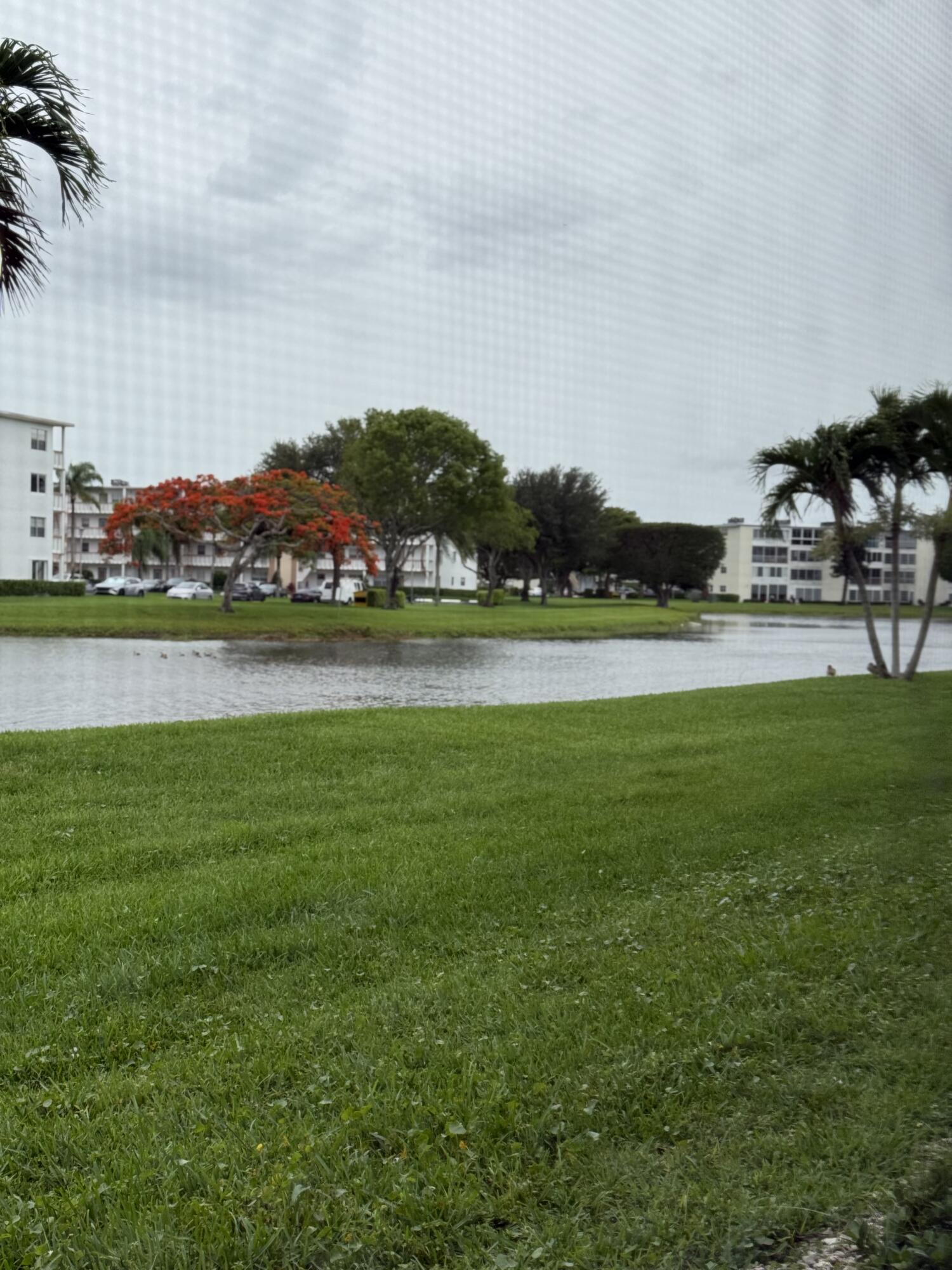 1046 Wolverton C Boca Raton, FL 33434 - Photo 16 of 17 a view of a green field with mountains in the background