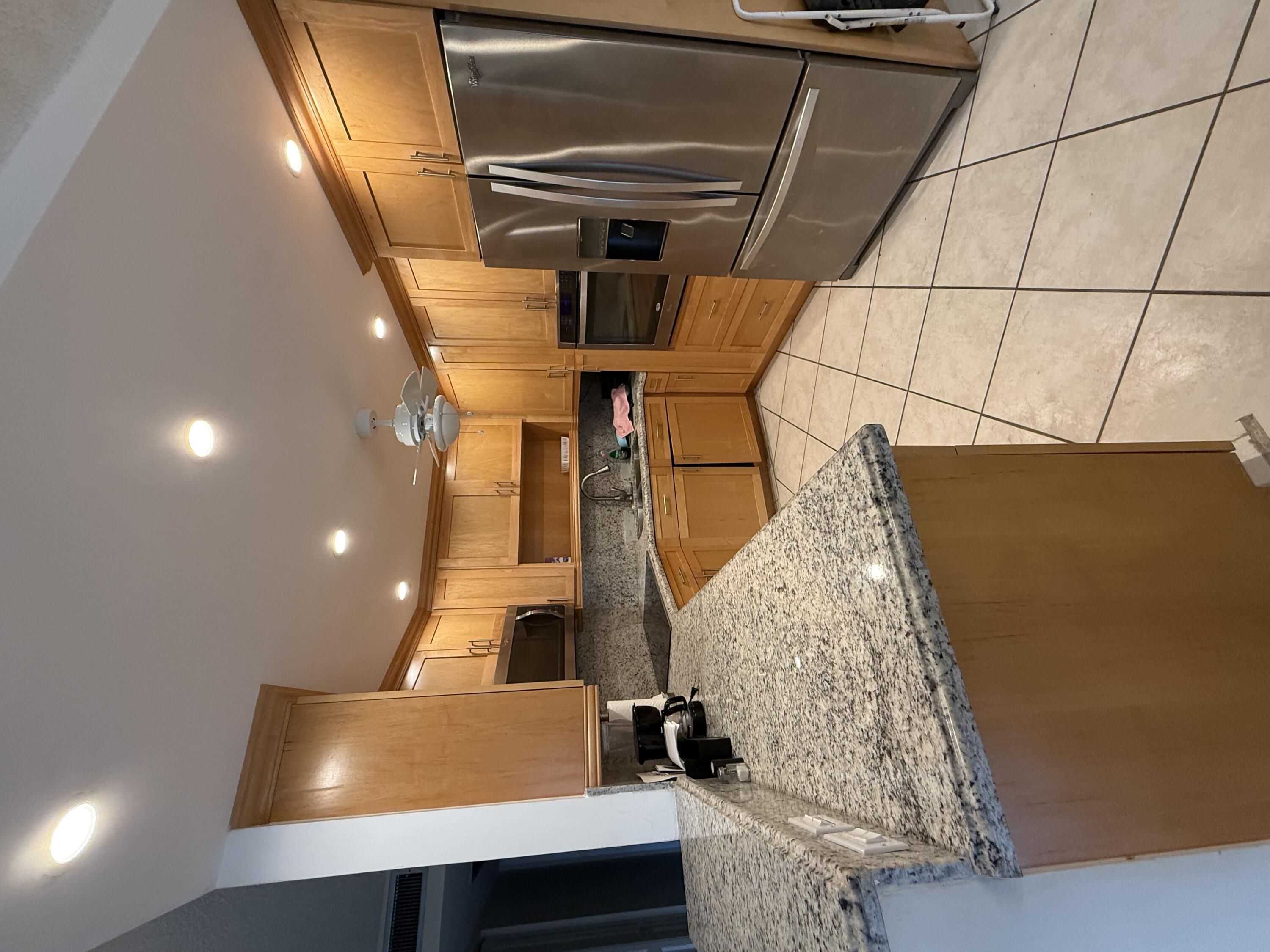 1046 Wolverton C Boca Raton, FL 33434 - Photo 2 of 17 a kitchen with stainless steel appliances granite countertop a sink refrigerator and cabinets