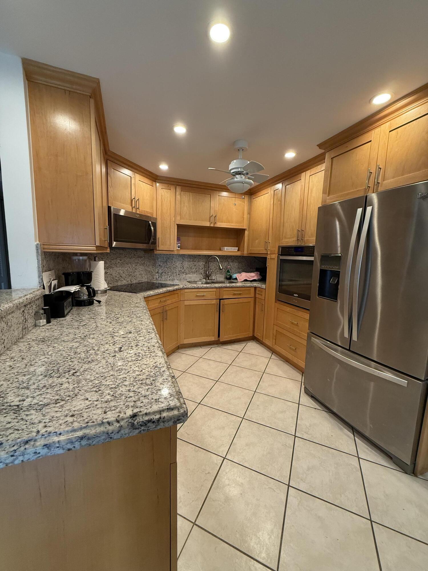 1046 Wolverton C Boca Raton, FL 33434 - Photo 4 of 17 a kitchen with stainless steel appliances granite countertop a sink stove and refrigerator
