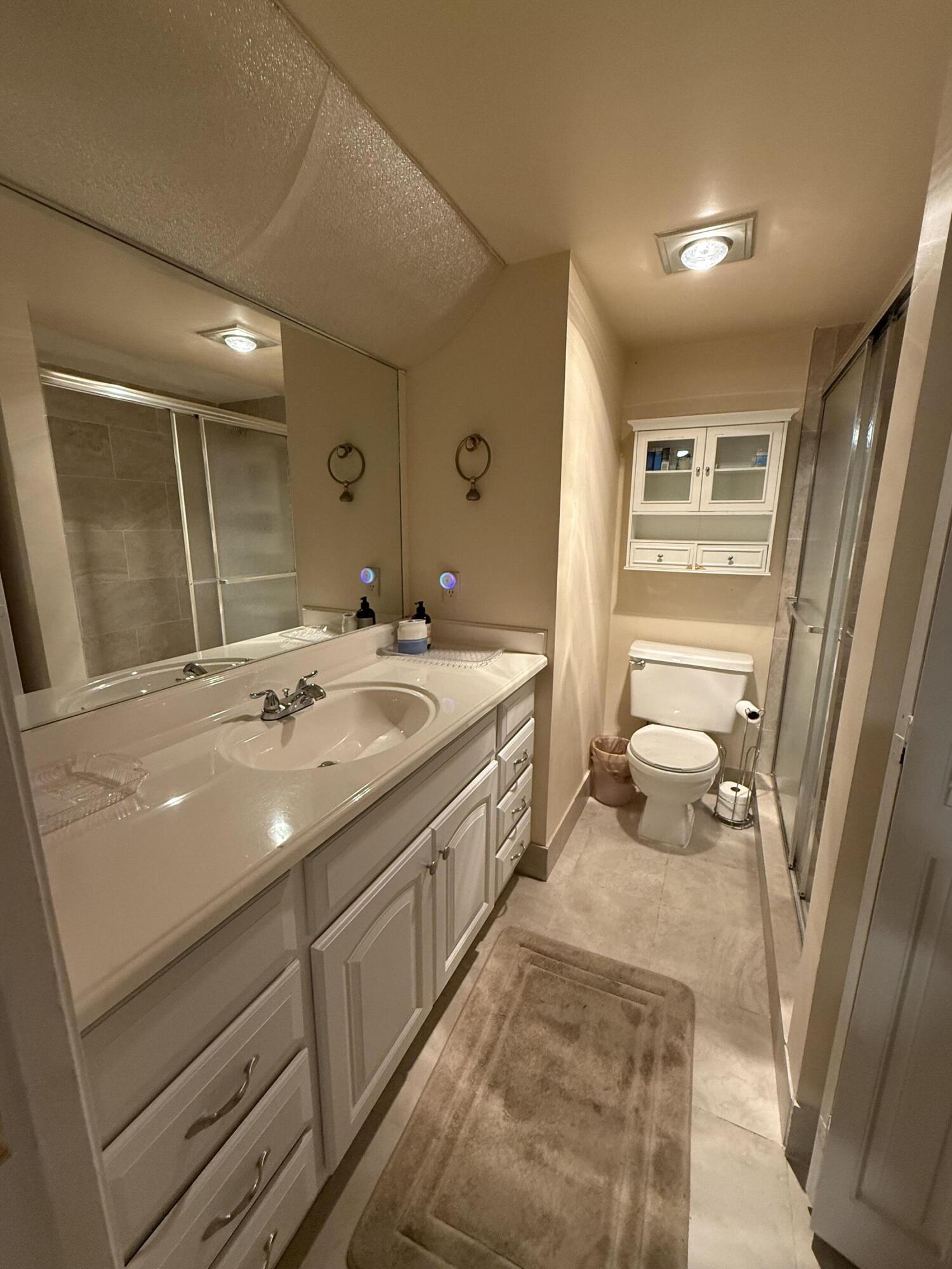 1046 Wolverton C Boca Raton, FL 33434 - Photo 8 of 17 a bathroom with a sink a toilet and shower