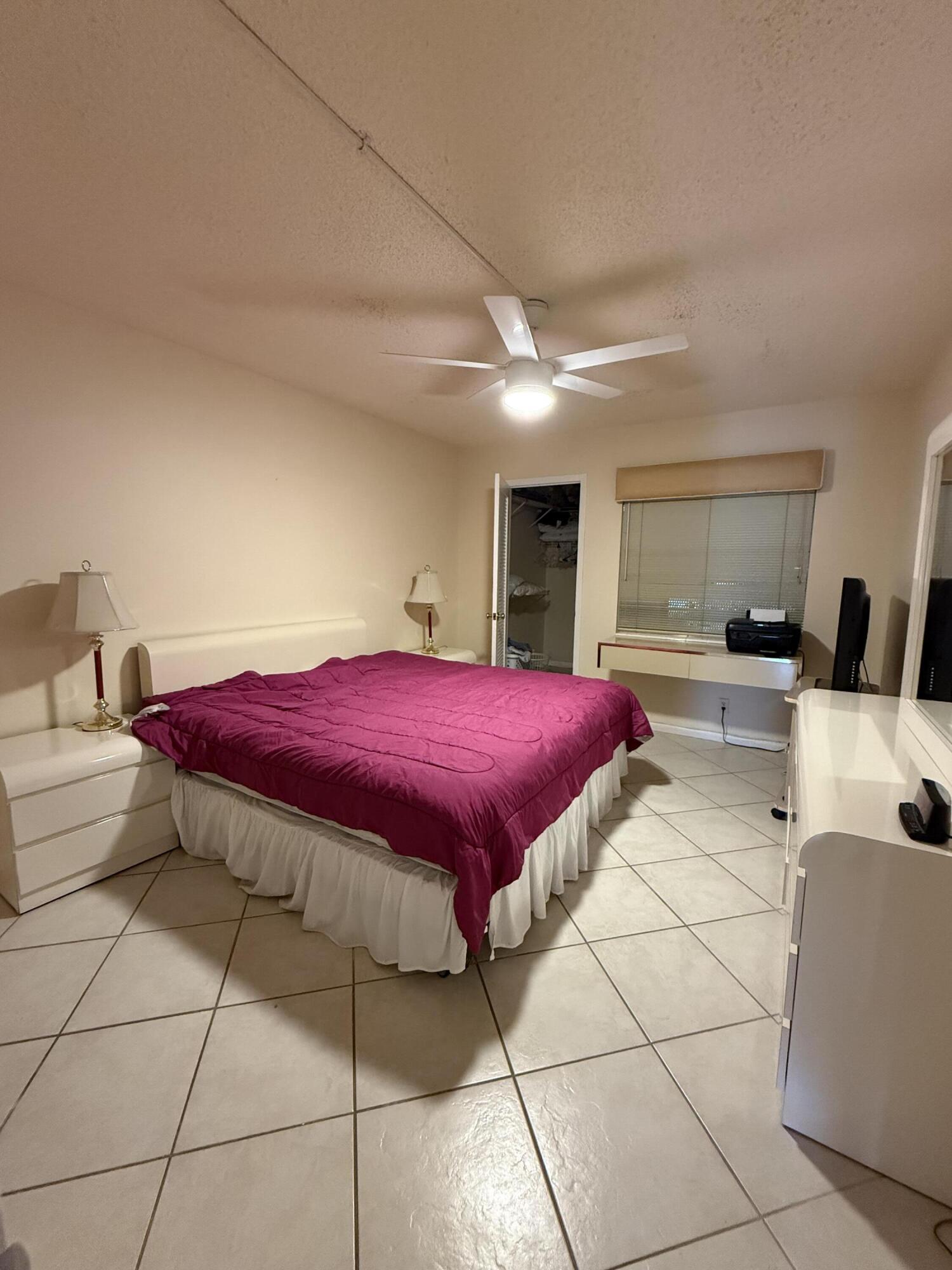 1046 Wolverton C Boca Raton, FL 33434 - Photo 10 of 17 a spacious bedroom with a bed and a view of kitchen