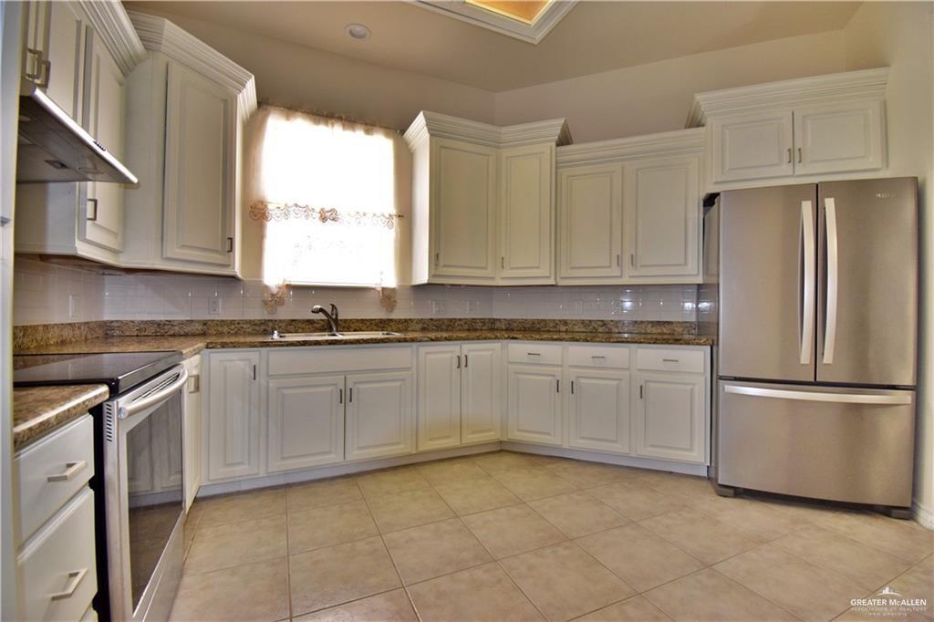 1104 Rio Balsas Mission, TX 78572 - Photo 4 of 20 Kitchen featuring stainless steel appliances, wall chimney range hood, dark stone countertops, and backsplash