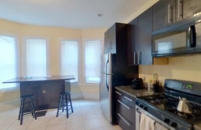 3147-3149 Washington Street, Unit 2 Boston, MA 02130 - Photo 1 of 5 a kitchen with stainless steel appliances granite countertop a stove and a refrigerator