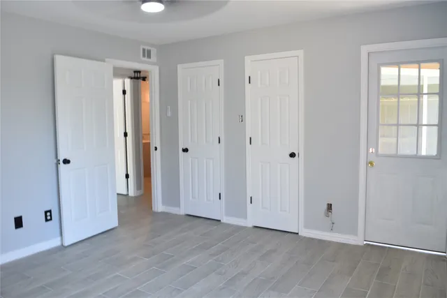 a view of empty room with wooden floor