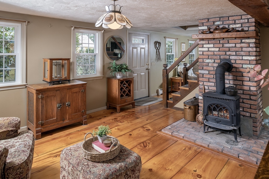 66 Main Street Plympton, MA 02367 - Photo 2 of 31 a living room with furniture a fireplace and a chandelier