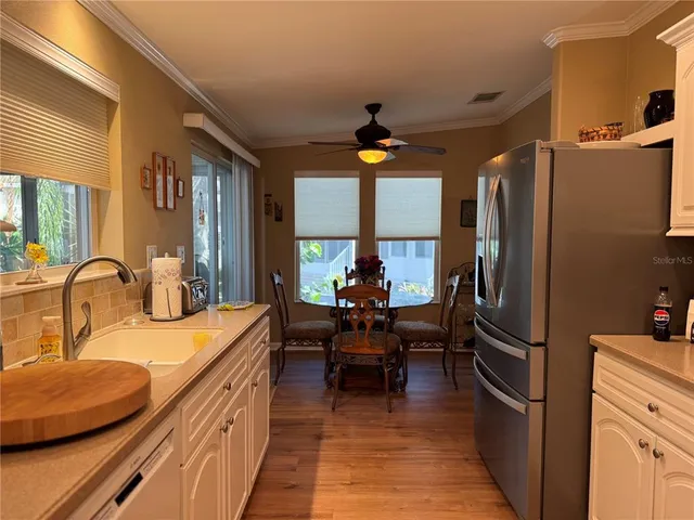 a kitchen with kitchen island a counter top space a sink appliances and a dining table