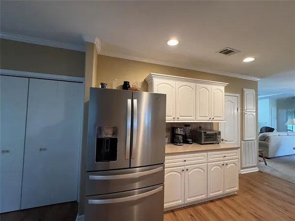 a kitchen with white cabinets and black appliances