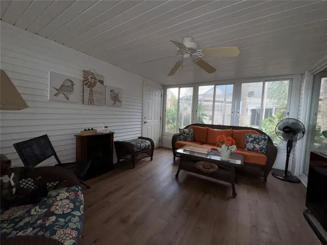 a living room with furniture a rug potted plant and a large window