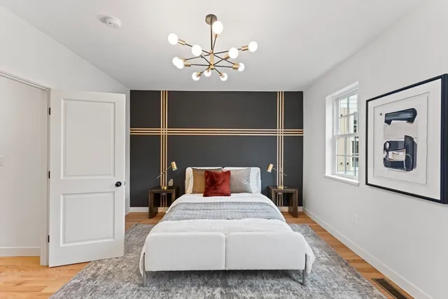 a bedroom with a large bed and a chandelier