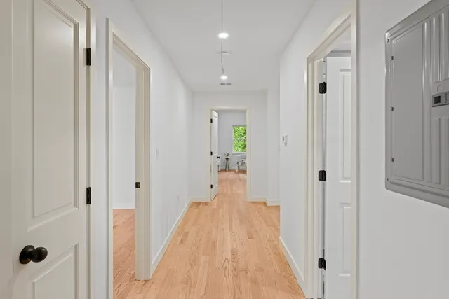 a view of a hallway with wooden floor and staircase
