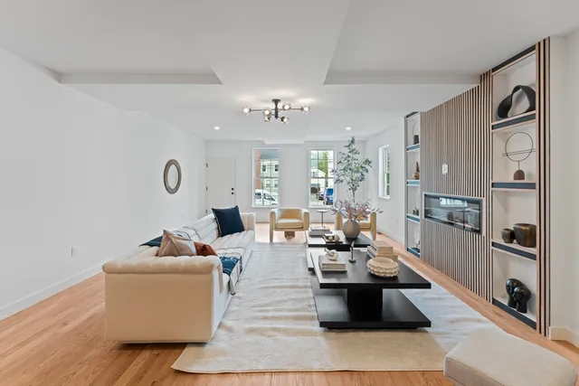 a living room with patio furniture and a chandelier