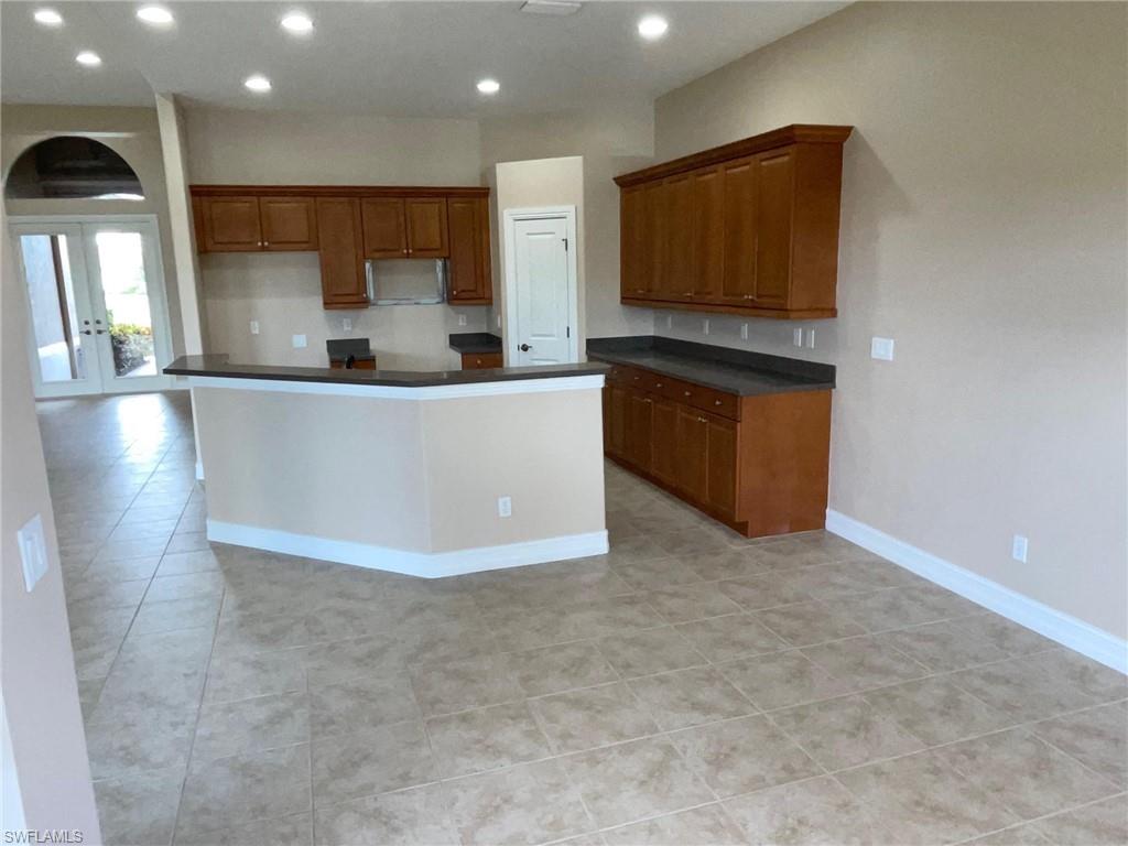 6082 Divot Court Naples, FL 34113 - Photo 11 of 39 a large kitchen with stainless steel appliances a large counter top