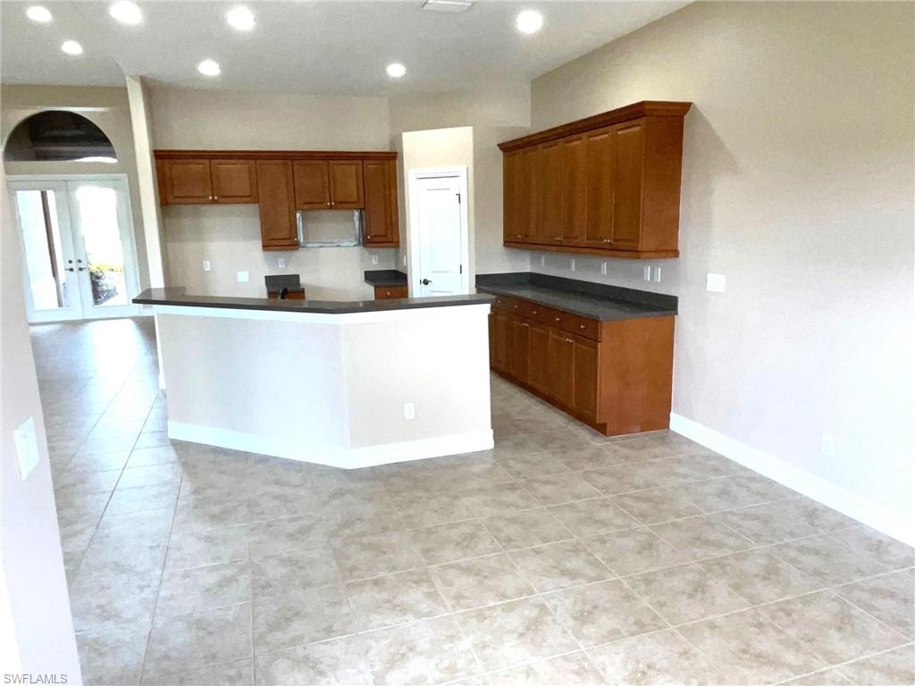 6082 Divot Court Naples, FL 34113 - Photo 12 of 39 a white refrigerator freezer sitting inside of a kitchen