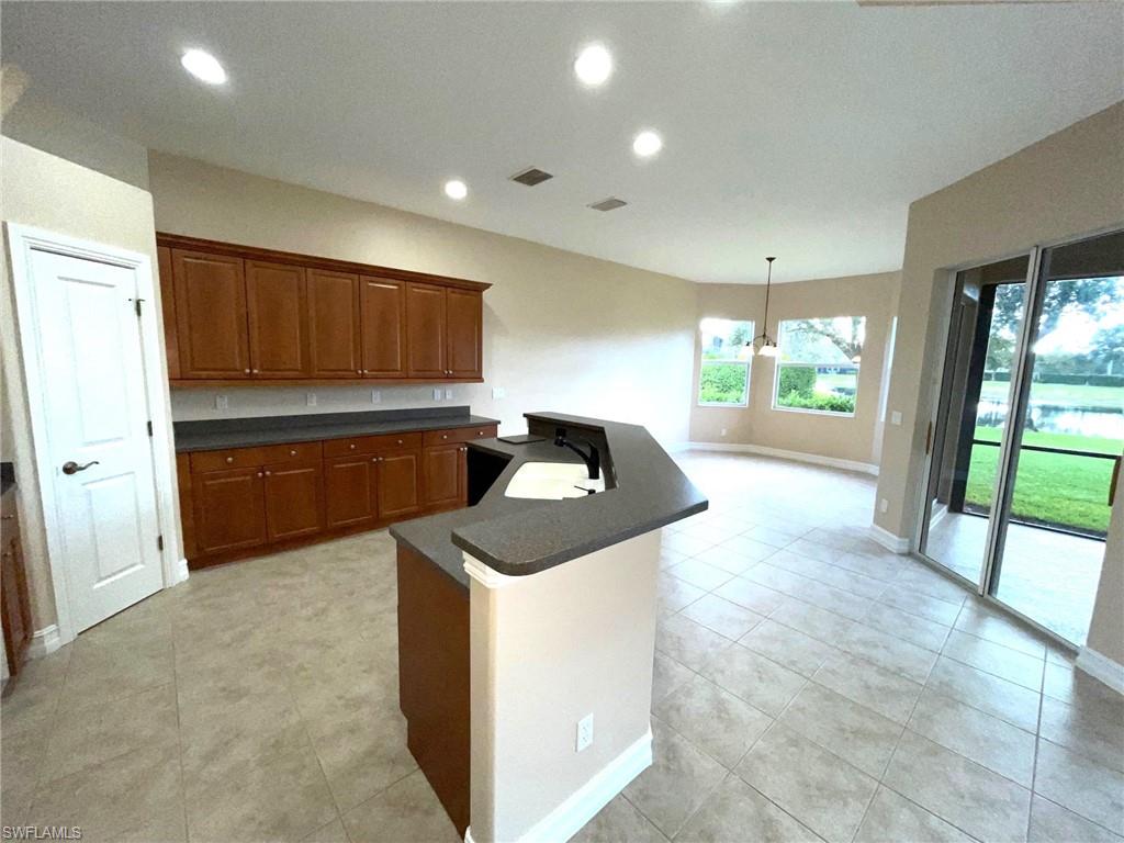 6082 Divot Court Naples, FL 34113 - Photo 16 of 39 a kitchen with granite countertop a sink and a stove top oven