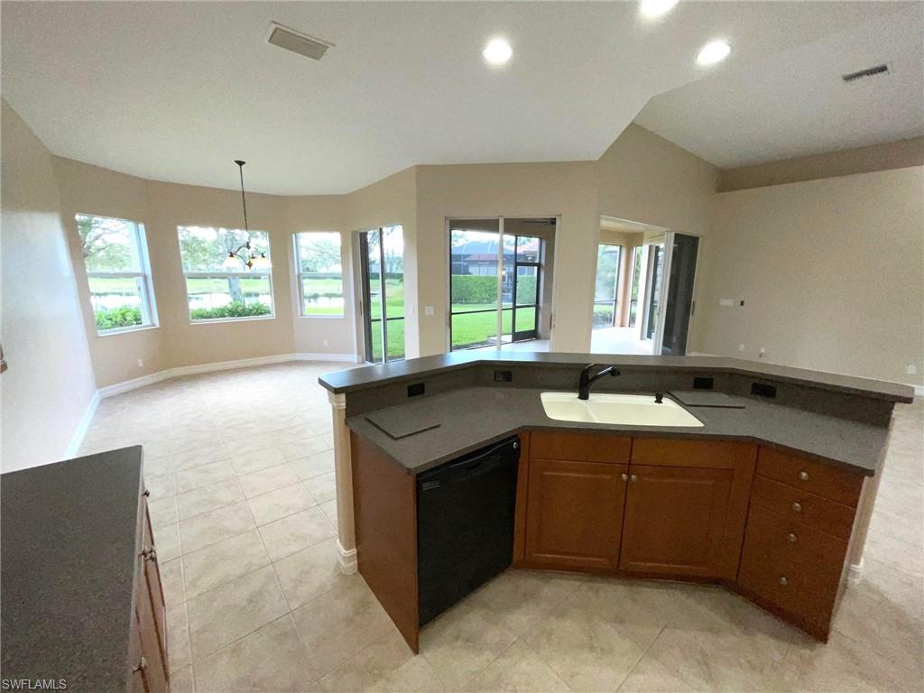 6082 Divot Court Naples, FL 34113 - Photo 17 of 39 a view of a kitchen with a sink and windows