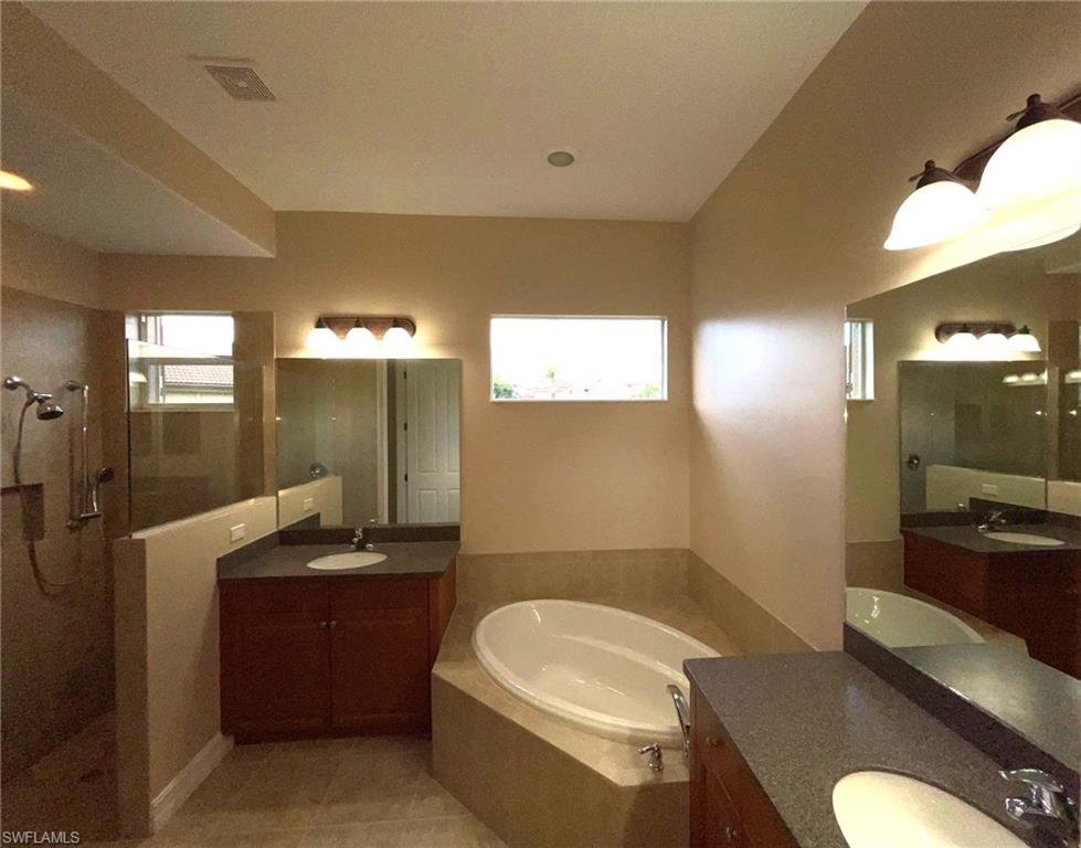 6082 Divot Court Naples, FL 34113 - Photo 24 of 39 a bathroom with a granite countertop sink mirror vanity and toilet