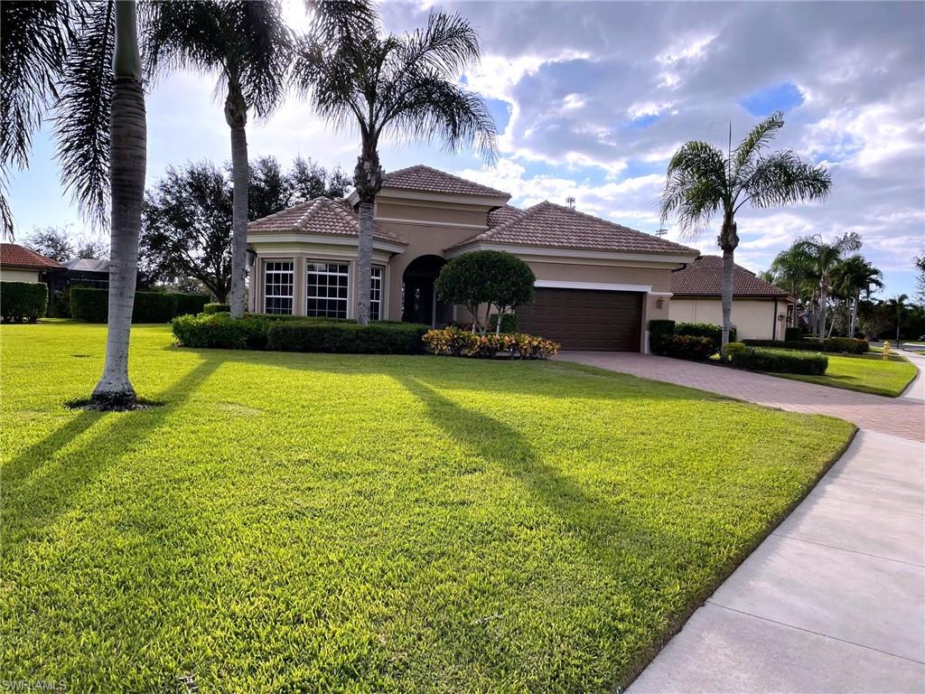 6082 Divot Court Naples, FL 34113 - Photo 27 of 39 a view of a house with swimming pool and a yard