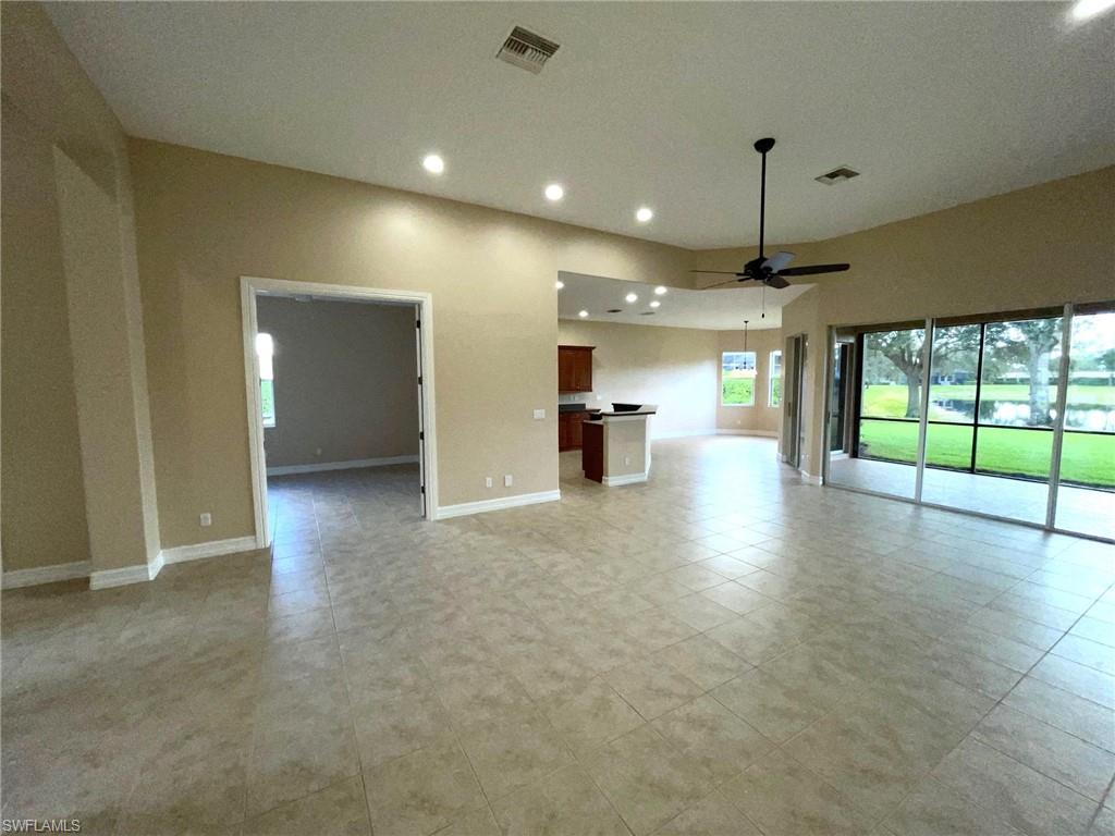 6082 Divot Court Naples, FL 34113 - Photo 5 of 39 an empty room with fireplace and windows
