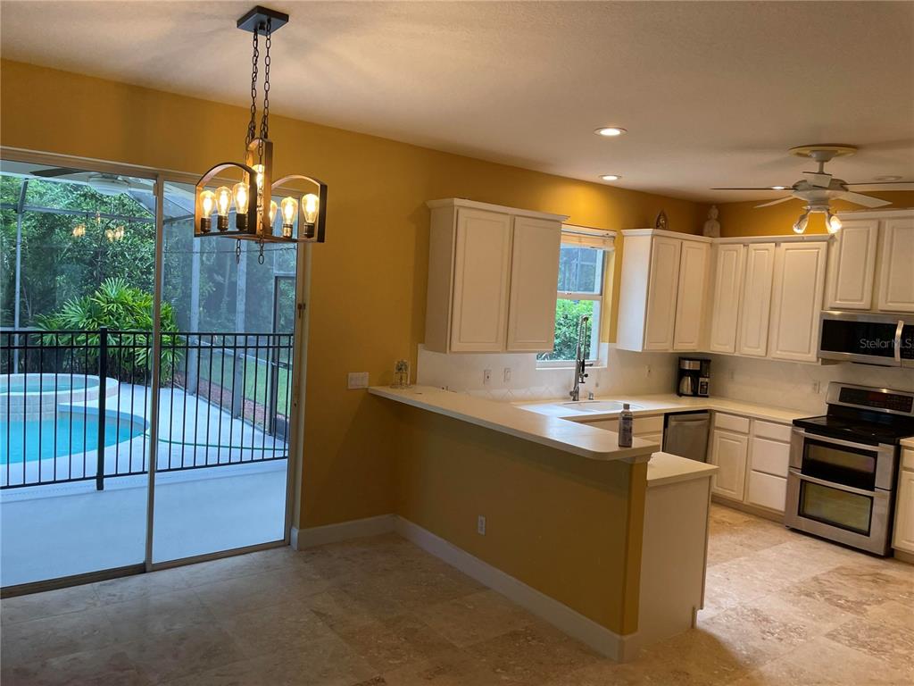 759 Fordingbridge Way Osprey, FL 34229 - Photo 27 of 51 a kitchen with stainless steel appliances granite countertop a sink a stove and a wooden floors