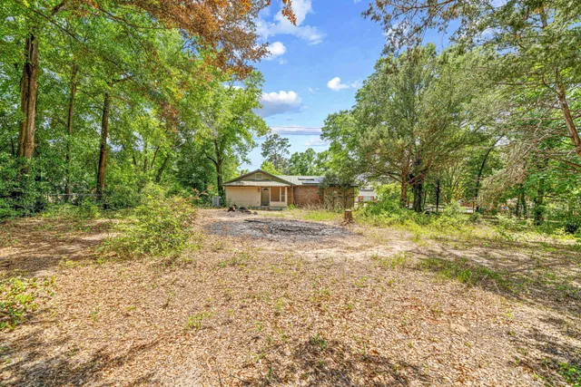 a yellow house with trees in front of it